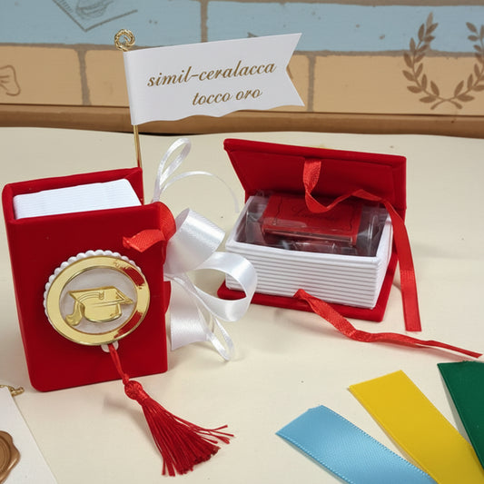 modello simil ceralacca tocco oro scatolina originale portaconfetti bomboniera laurea segnaposto festa confezionata confetti bigliettino personalizzabile con colore nastrino raso, allestimento con tocco cappello e nappina muro con simboli grafici corona alloro