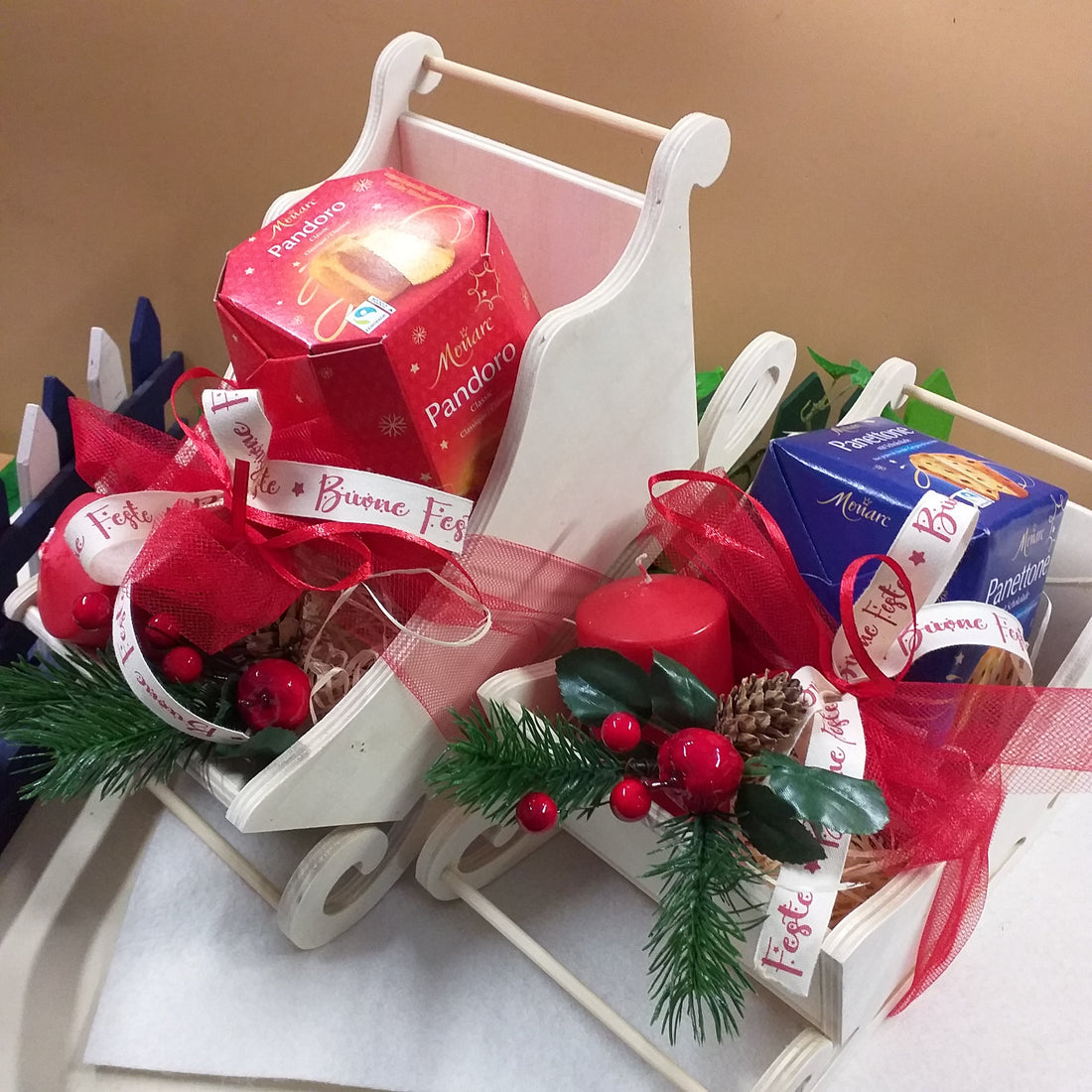 idee come confezionare slitte legno pick rametto pino bacche natalizie candele rosse nastro auguri buone feste con mini panettone pandoro porzione per bambini