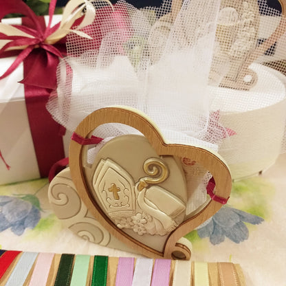 primo piano confezionamento ricordino pensierino di resina legno icone sacre cuore Sentimental confezionate confetti con sacchetti tulle Comunione Cresima bomboniere religiose simboli cerimonia Calice spighe uva Mitria pastorale