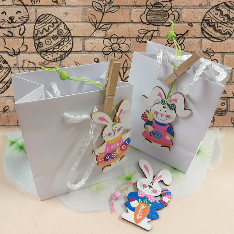 sportine borsine bianche shopper mini confezionamento con  ciondoli coniglietti pasquali colorati arancio rosa blu happy easter scritta welcome ovetti fiori uso packaging segnaposto idea regalo sorpresa ovetti cioccolato gadget souvenir