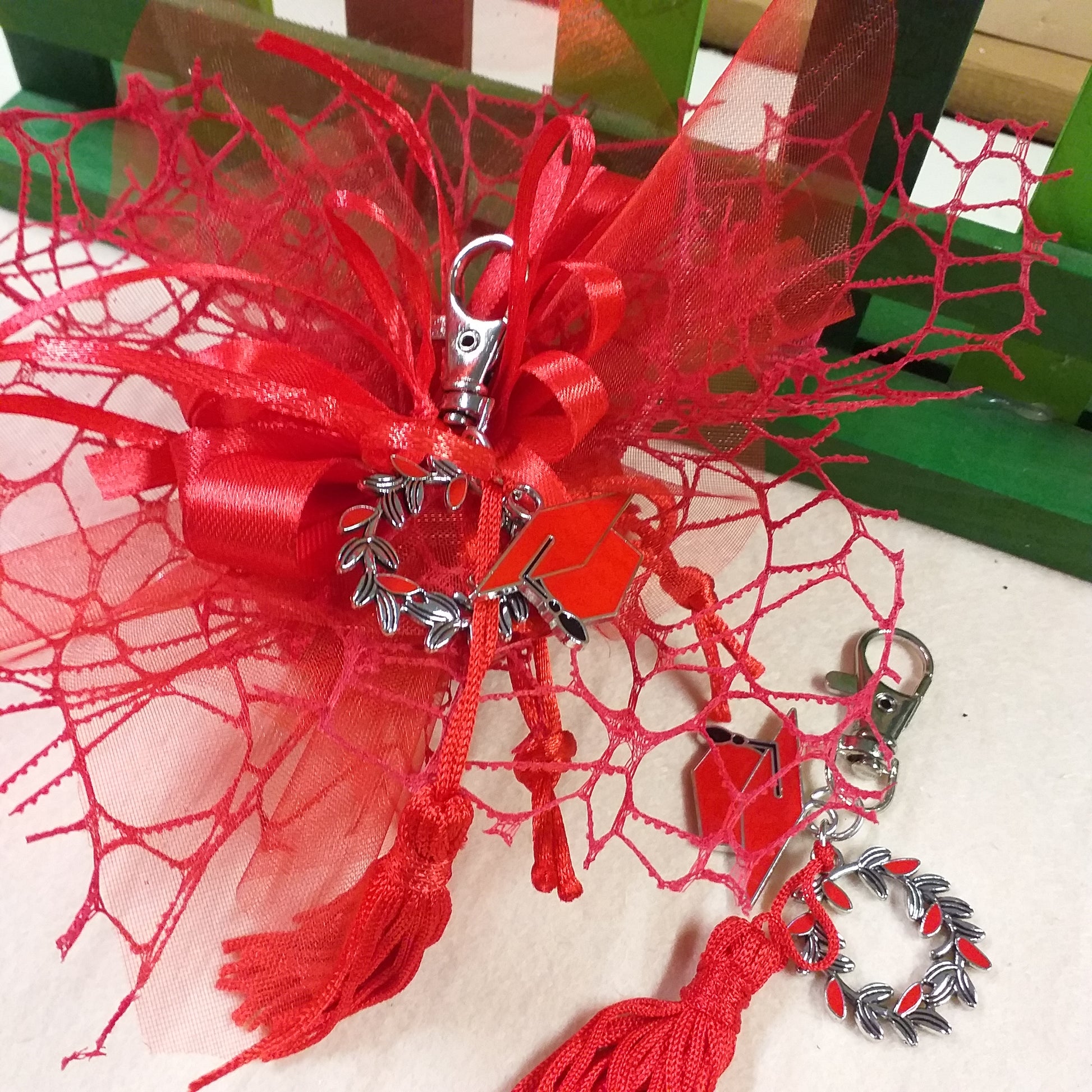 allestimento portaconfetti laurea confezionare packaging composizione nastro bigliettino bomboniera confetti portachiavi laurea di metallo corona d'alloro cappello smaltato tocco nappina