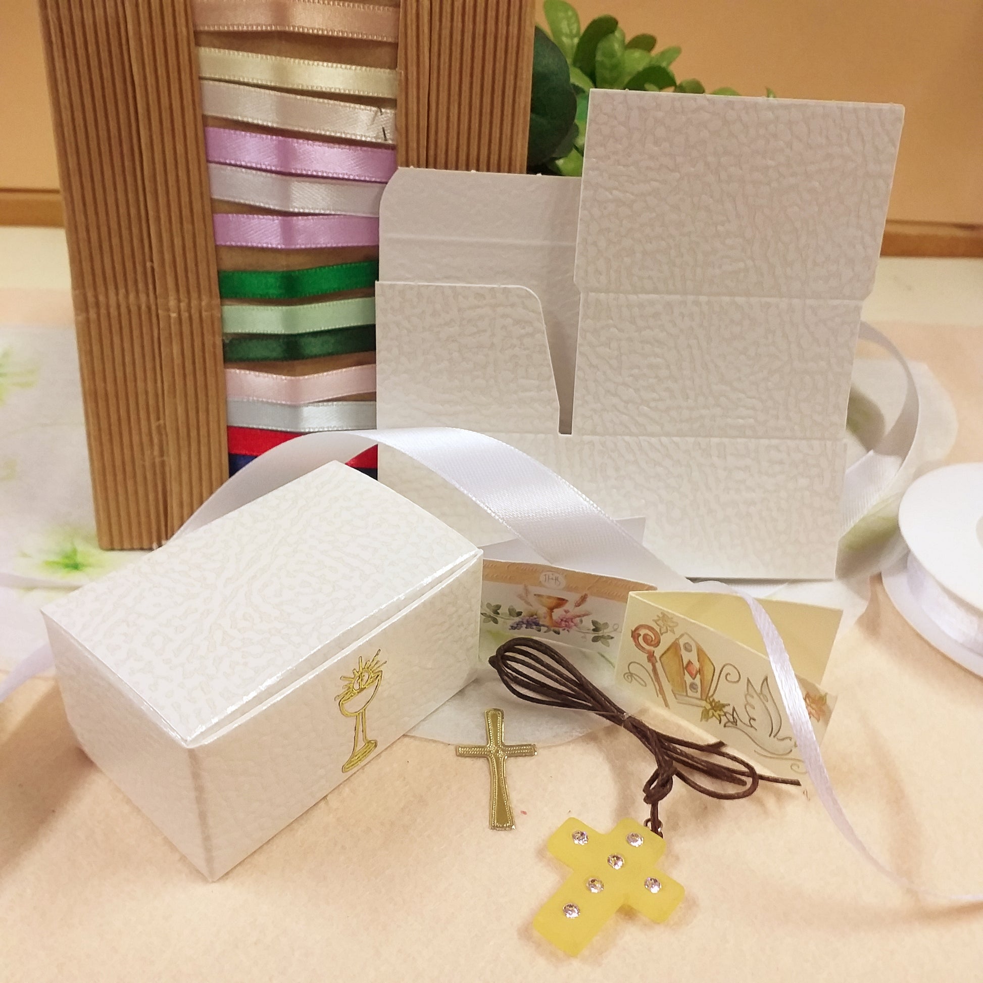 kit fai da te per confezionare con ciondolo Croce simil-polaris resina gialla strass brillantini collanina cordino marrone bomboniera Prima Comunione Santa Cresima scatoline bianche astucci bigliettino simboli Calice spighe uva Mitria Colomba colori nastrini raso