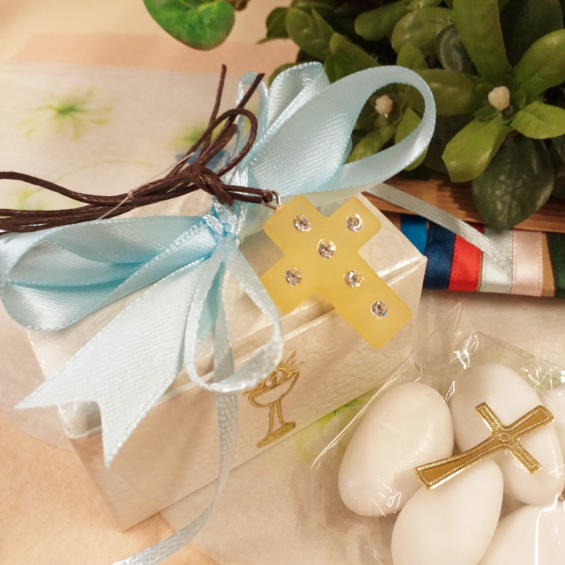 fiocco bambino celeste ciondolo Croce simil-polaris resina gialla strass brillantini collanina cordino marrone bomboniera Prima Comunione Santa Cresima confezionata confetti con scatolina astuccio bianca bigliettino