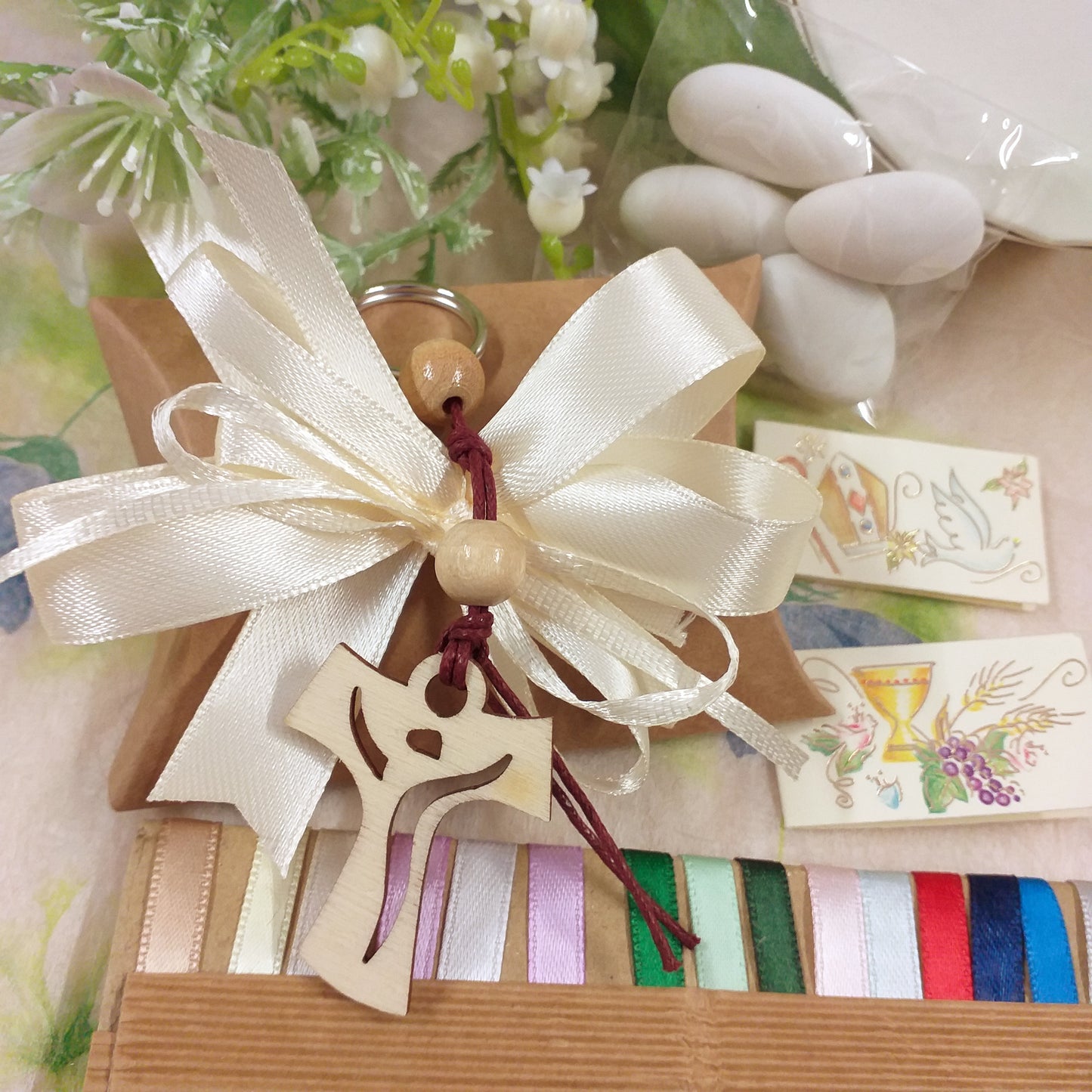 coccarda panna e bustina di cartoncino ecologico kraft bomboniera Comunione Cresima green Croce Tau Legno portachiavi perline cordino confezionata confetti italiani bigliettini nastrini