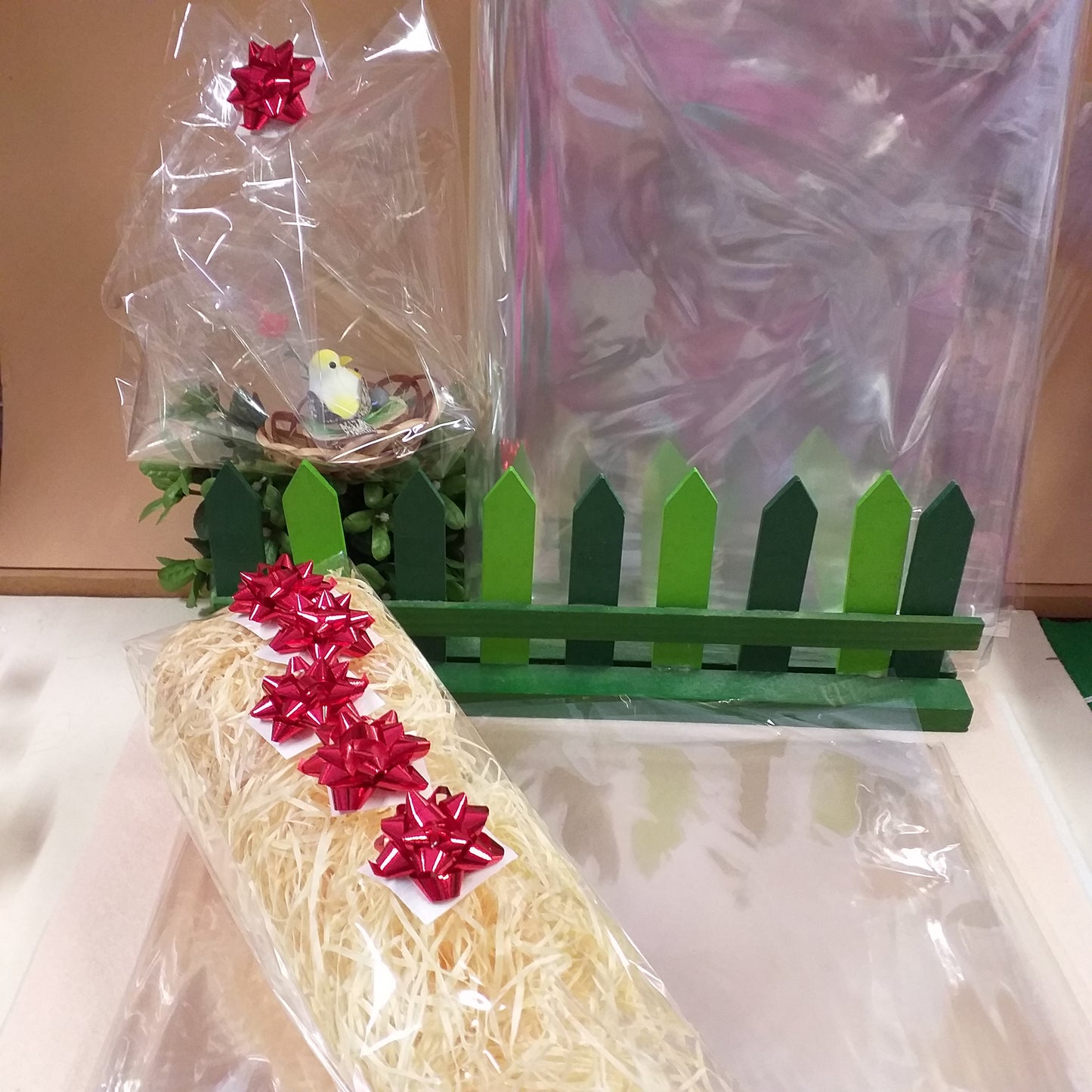 idea creativa cestino pasquale confezione cellophane trasparente vendita fogli paglietta di legno riempitivo 5 coccardine rosse di carta metallizzata per packaging cesti regalo kit fai da te