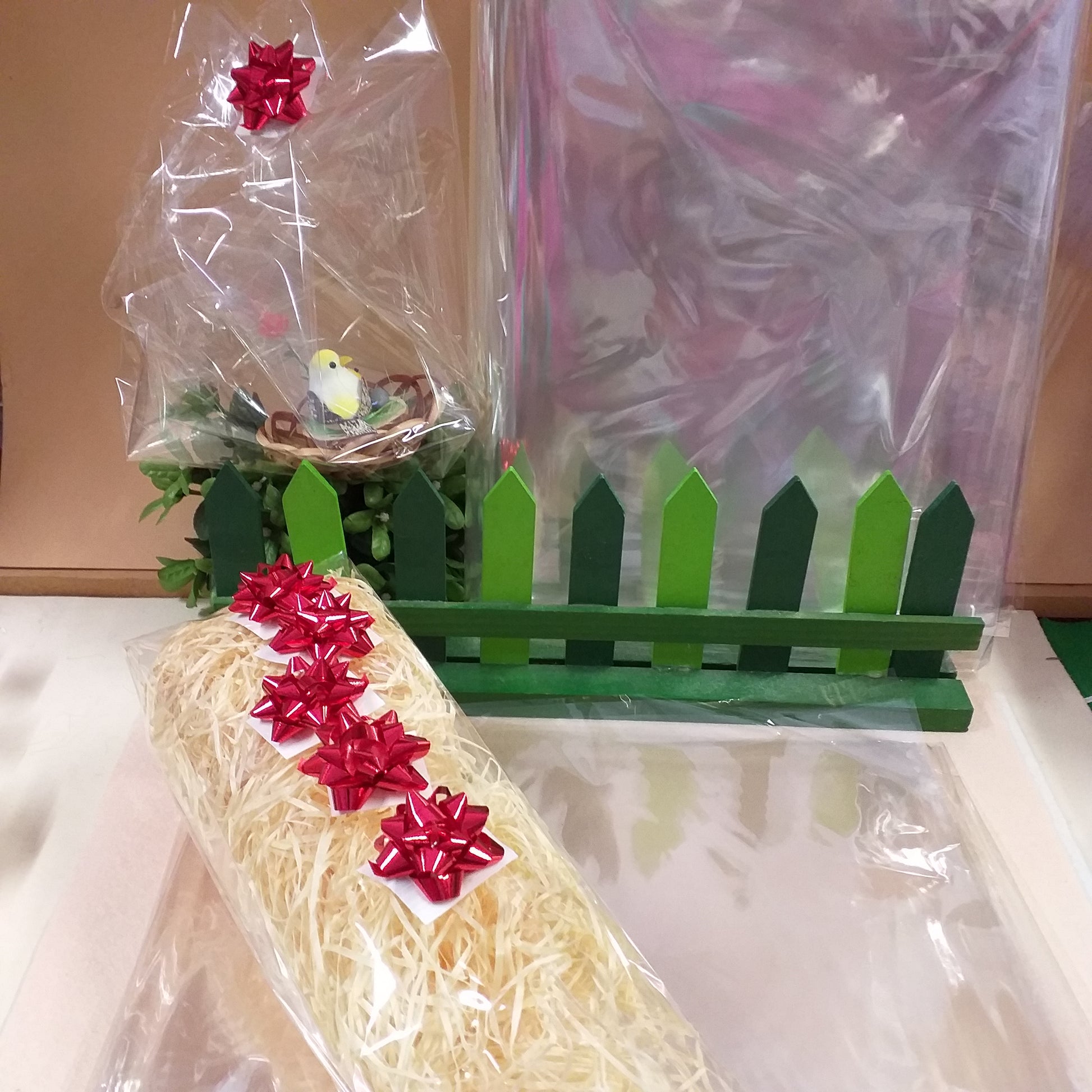 idea creativa cestino pasquale confezione cellophane trasparente vendita fogli paglietta di legno riempitivo 5 coccardine rosse di carta metallizzata per packaging cesti regalo kit fai da te