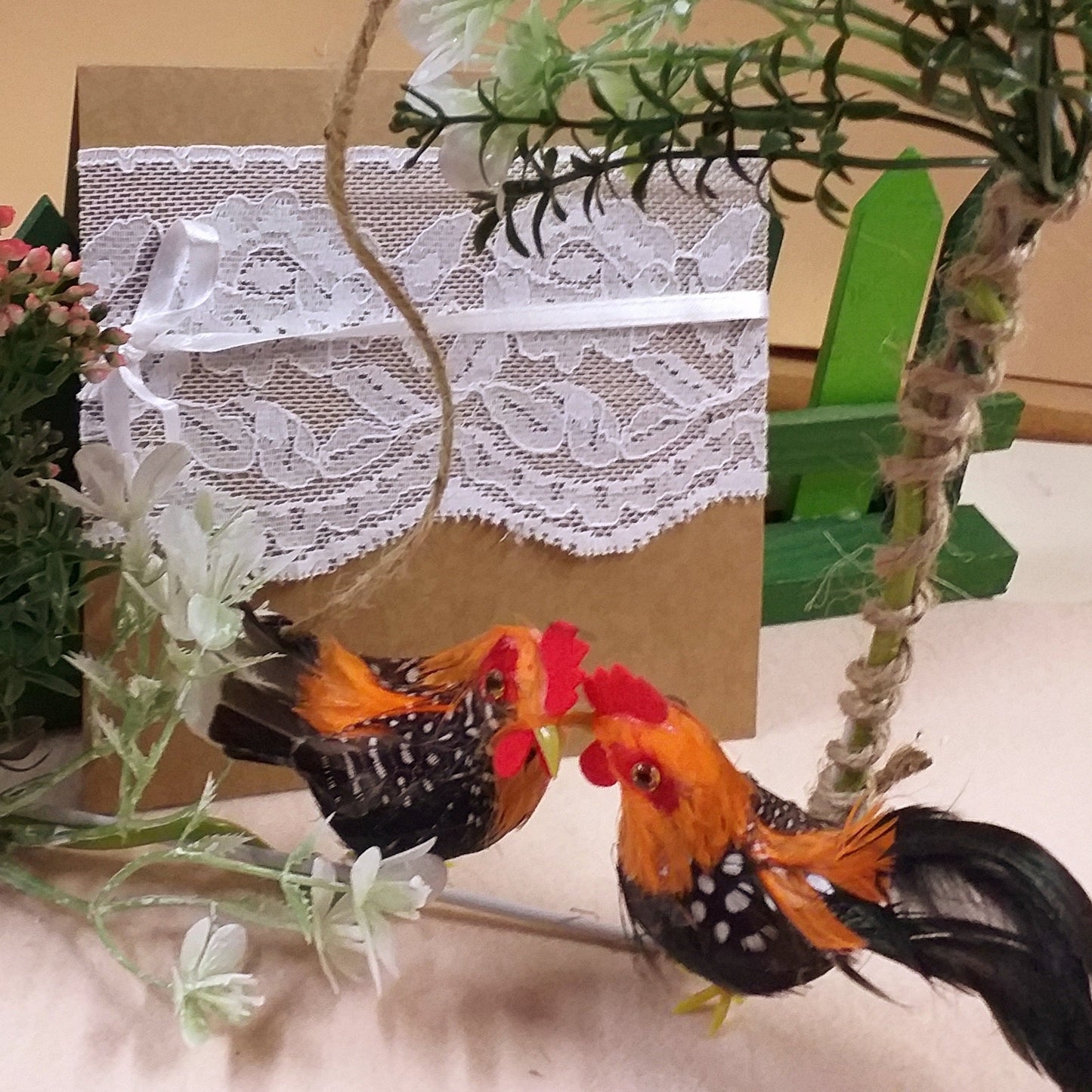 dialogo gallo gallina dettaglio casetta di metallo ferro bianco rivestita filo juta ghirlanda fuoriporta pasquali da appendere decorazioni fiori rosa bianchi fiorellini miniature