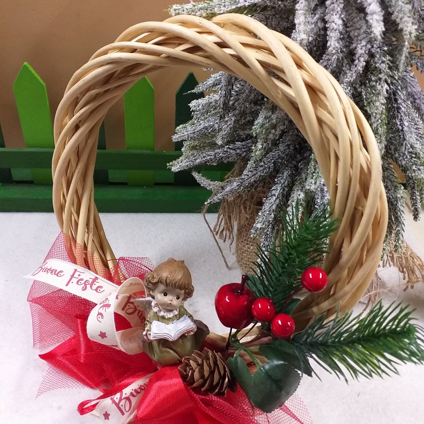 angioletto in lettura ghirlanda coroncina fuoriporta Natale idea regalo angelo nastro buone feste composizione pino bacche rosse pigna