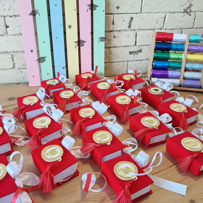 working in progress scatolina originale portaconfetti bomboniera laurea segnaposto festa confezionata confetti bigliettino personalizzabile con colore nastrino raso, allestimento tocco cappello e nappina muro con simboli grafici pergamena corona alloro 