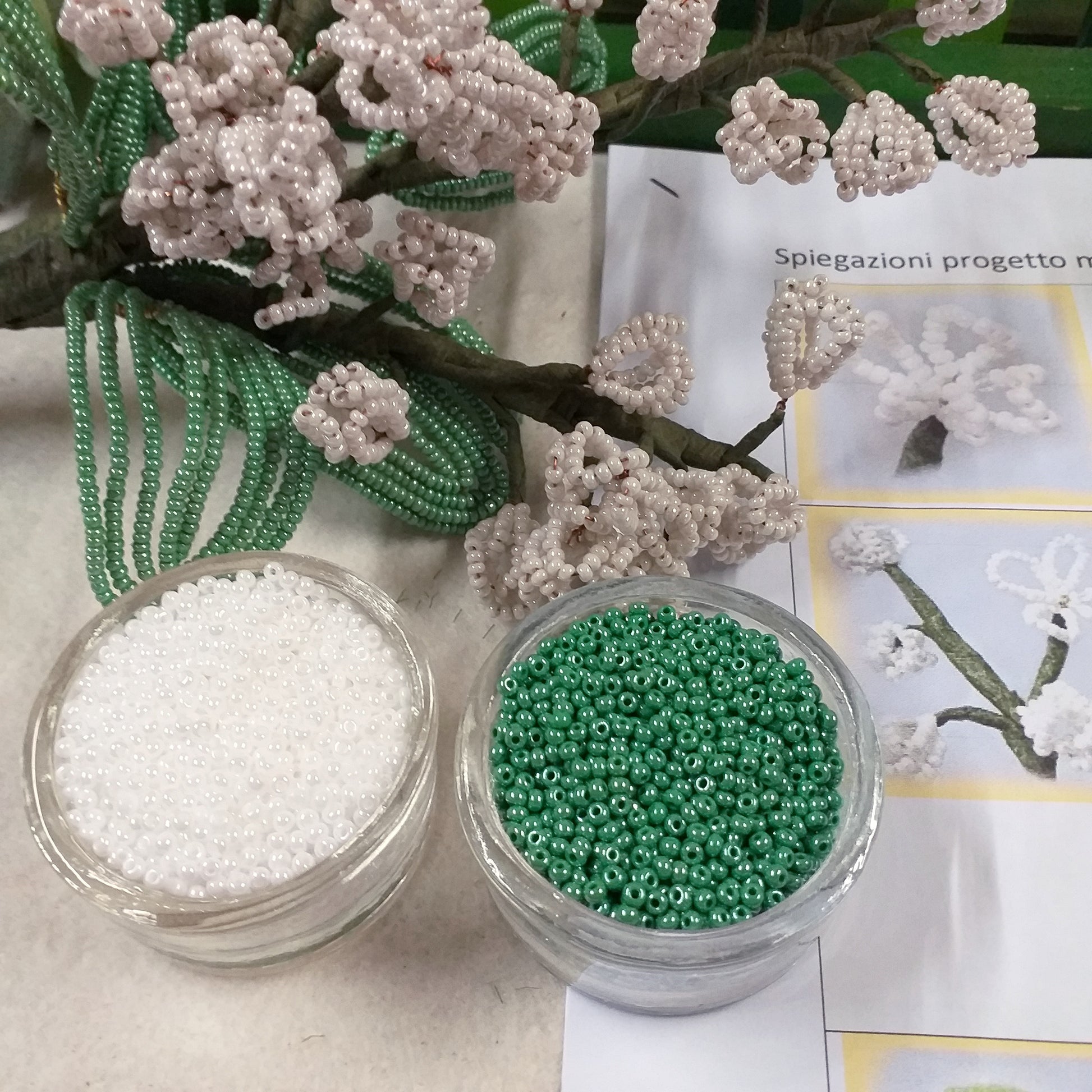 primo piano kit materiali occorrente foto tutorial spiegazioni creare mughetti perline fiori bianchi per bomboniere matrimonio bouquet sposa centrotavola rocailles beads conteria bianco verde