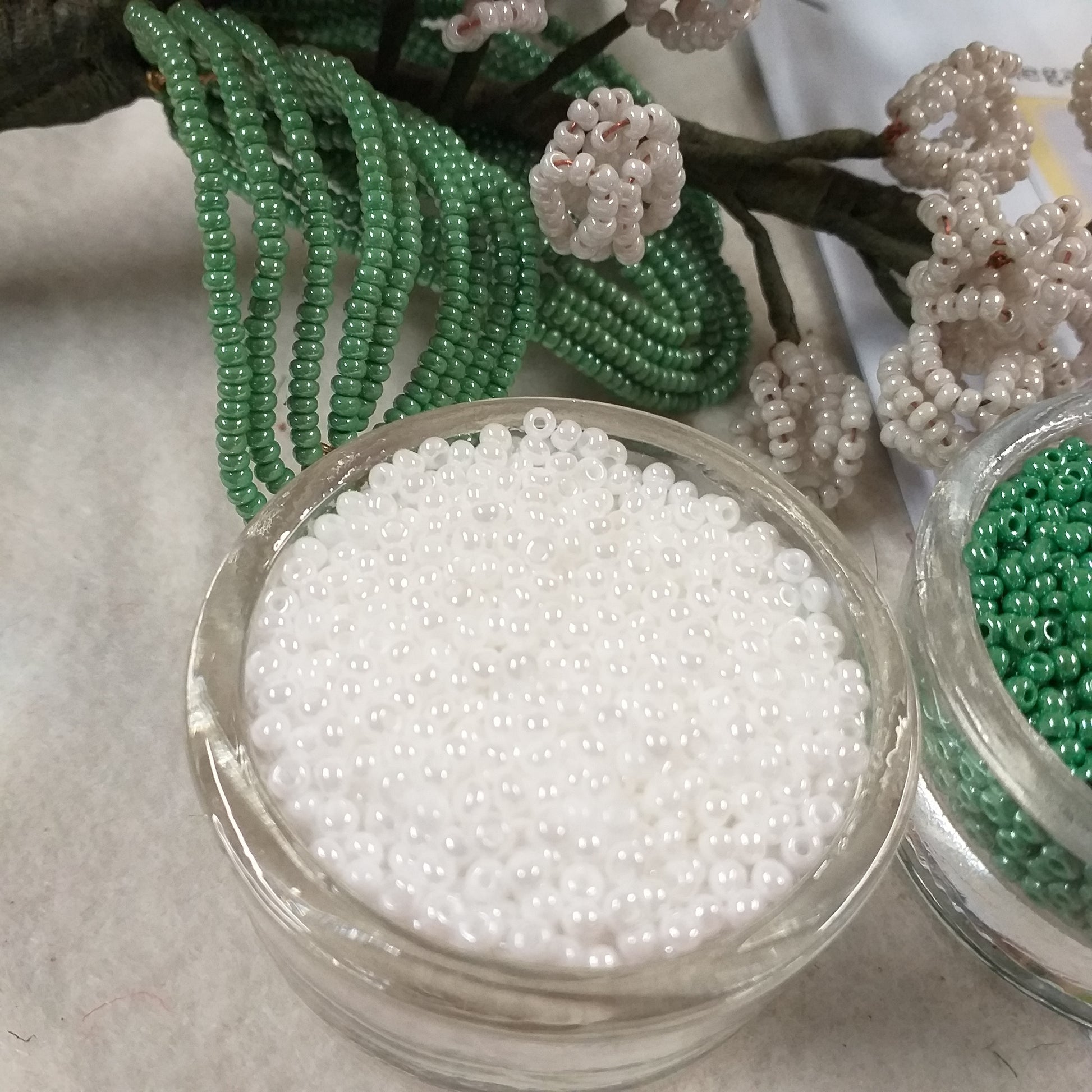 primo piano kit materiali occorrente foto tutorial spiegazioni creare mughetti perline fiori bianchi per bomboniere matrimonio bouquet sposa centrotavola rocailles beads conteria bianco perlato