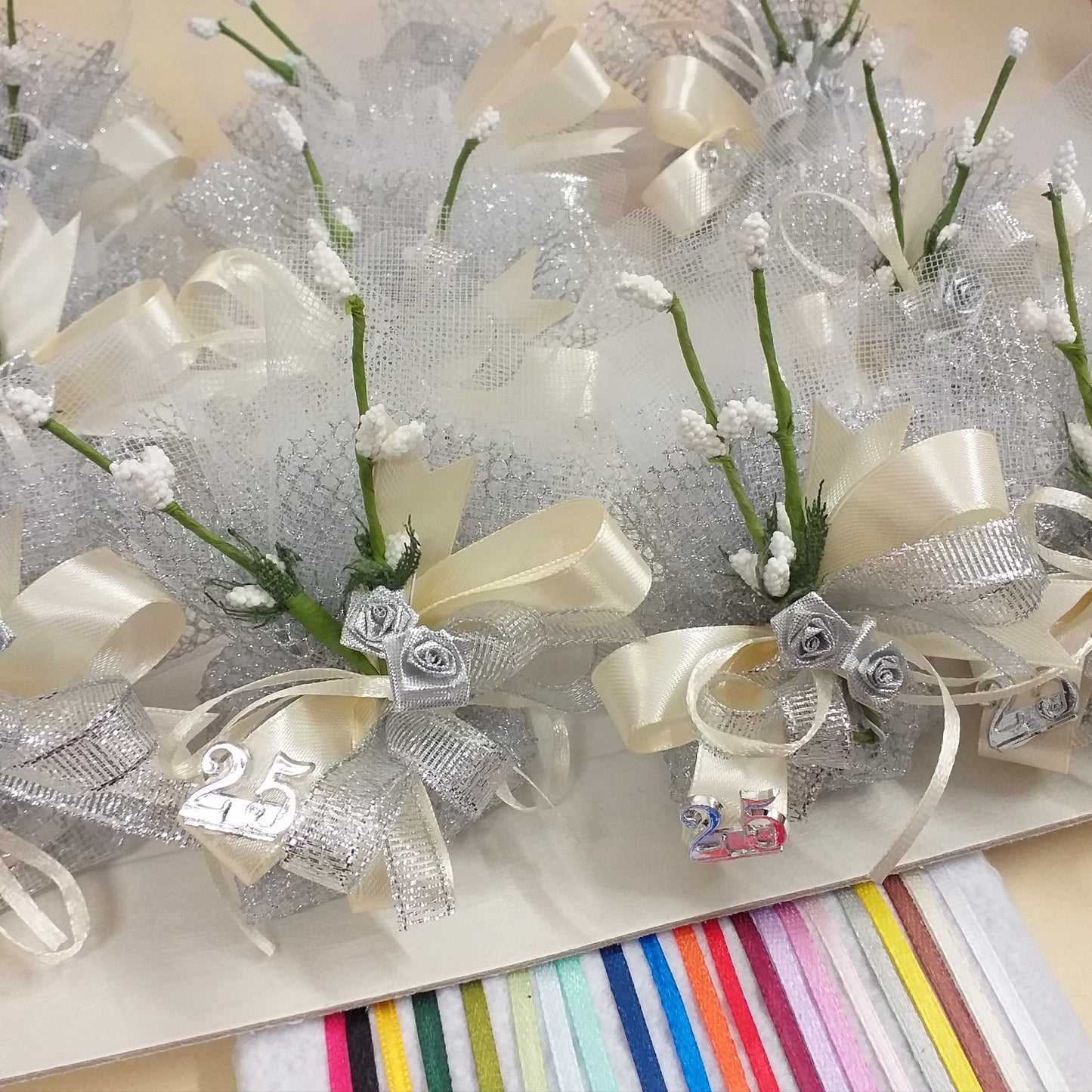 25 anni venticinquesimo nozze sacchetti rete argento simboli applicazioni rose argentate velo da sposa nebbiolina bianca coccarda nastro lurex e raso confetti mandorla cioccolato bianchi argentati bomboniere anniversario matrimonio fiori confetti scelta colore nastrini