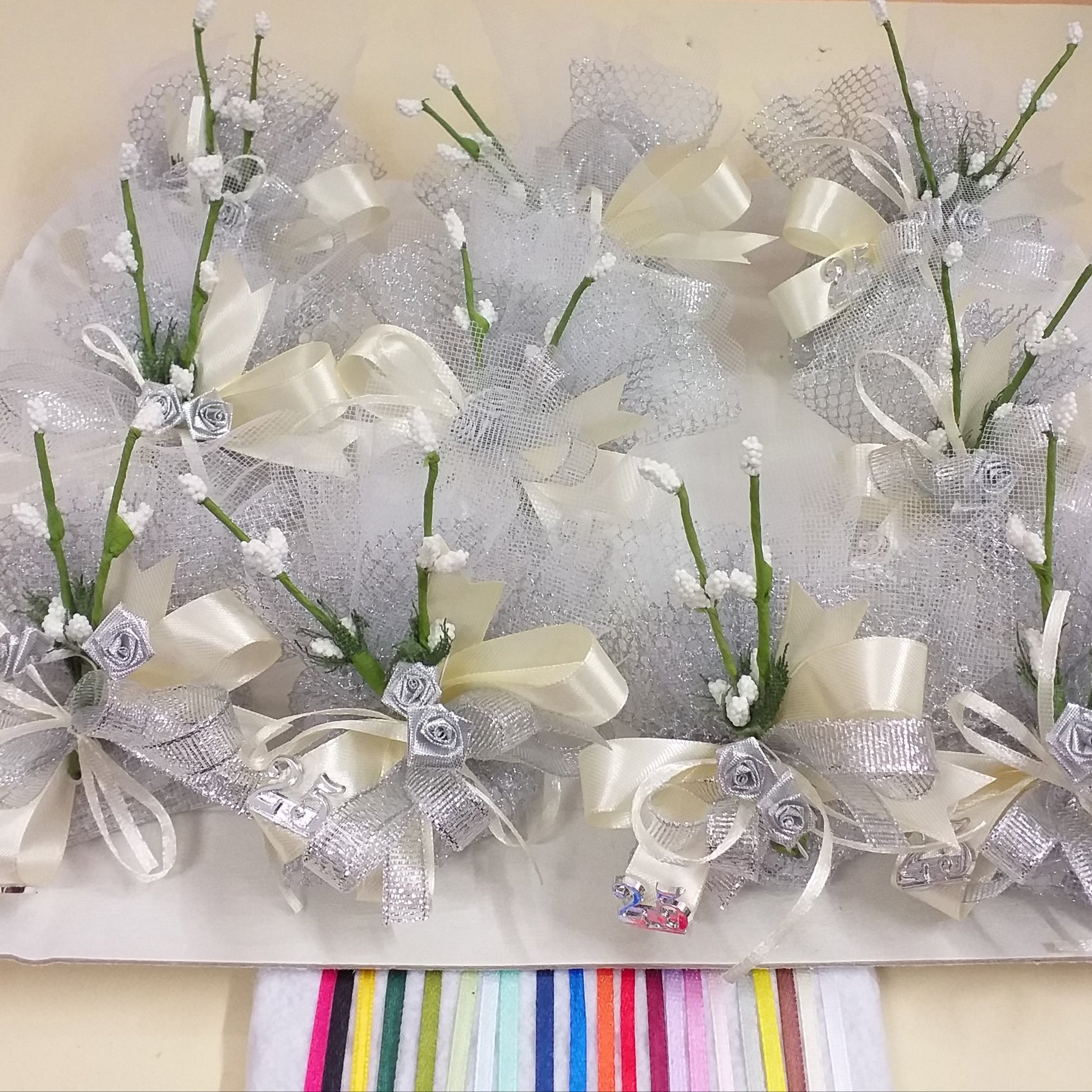 dall'alto composizione kit fai da te 25 anni venticinquesimo nozze sacchetti rete argento simboli applicazioni rose argentate velo da sposa nebbiolina bianca coccarda nastro lurex e raso confetti mandorla cioccolato bianchi argentati bomboniere anniversario matrimonio fiori confetti