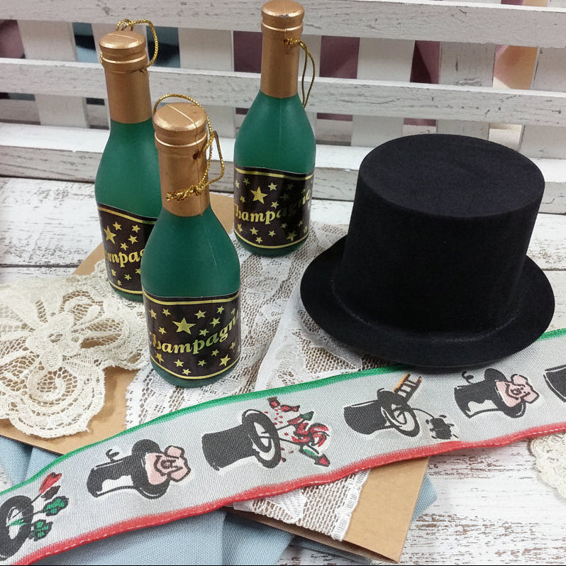 vetrina decorazioni capodanno materiali creativi segnaposto ultimo dell'anno San Silvestro nastro simboli portafortuna cappello cilindro nero bottigliette miniature plastica maialini funghetti quadrifoglio