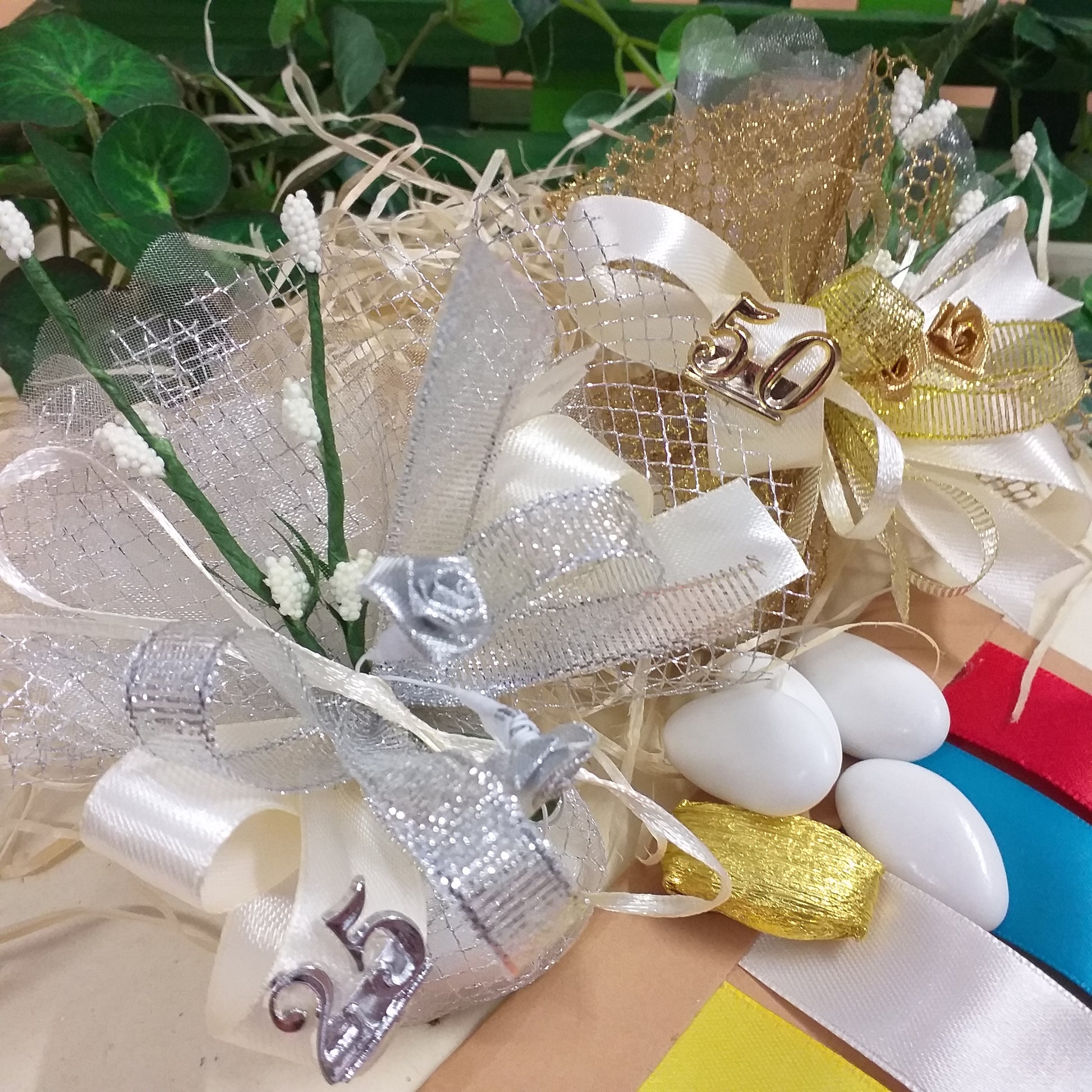 vetrina packaging anniversario sacchetti rete oro argento simboli applicazioni 50 e 25 anni rose dorate argentate velo da sposa nebbiolina bianca coccarda nastro lurex e raso confetti mandorla cioccolato bianchi dorati kit fai da te o confezionati bomboniere matrimonio