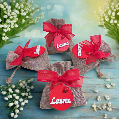 dall'alto bomboniere sacchetto juta particolare originale per laurea fai da te e confezionato ciondolo legnetto applicazione tag legno scritta coccinella nastro coccarda confetti bigliettino
