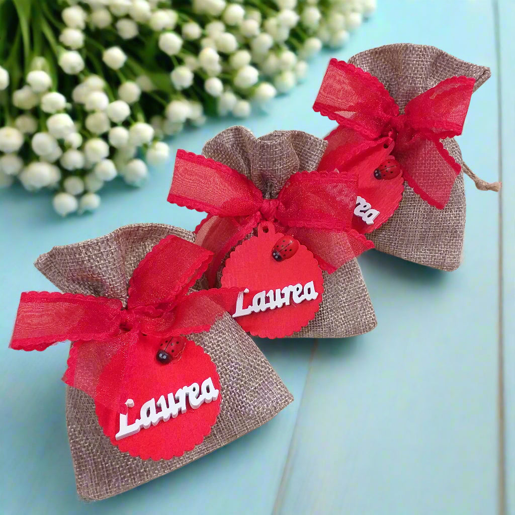 tris di bomboniere sacchetto juta particolare originale per laurea fai da te e confezionato ciondolo legnetto applicazione tag legno scritta coccinella nastro coccarda confetti bigliettino
