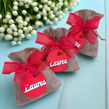 tris di bomboniere sacchetto juta particolare originale per laurea fai da te e confezionato ciondolo legnetto applicazione tag legno scritta coccinella nastro coccarda confetti bigliettino