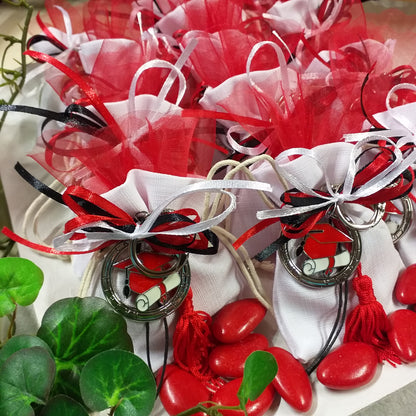 packaging sacchetto bianco confezionato confetti tulle tris colori nastrini bianco rosso nero portachiavi tocco cappello laurea ciondolo smaltato pergamena nappina bomboniera