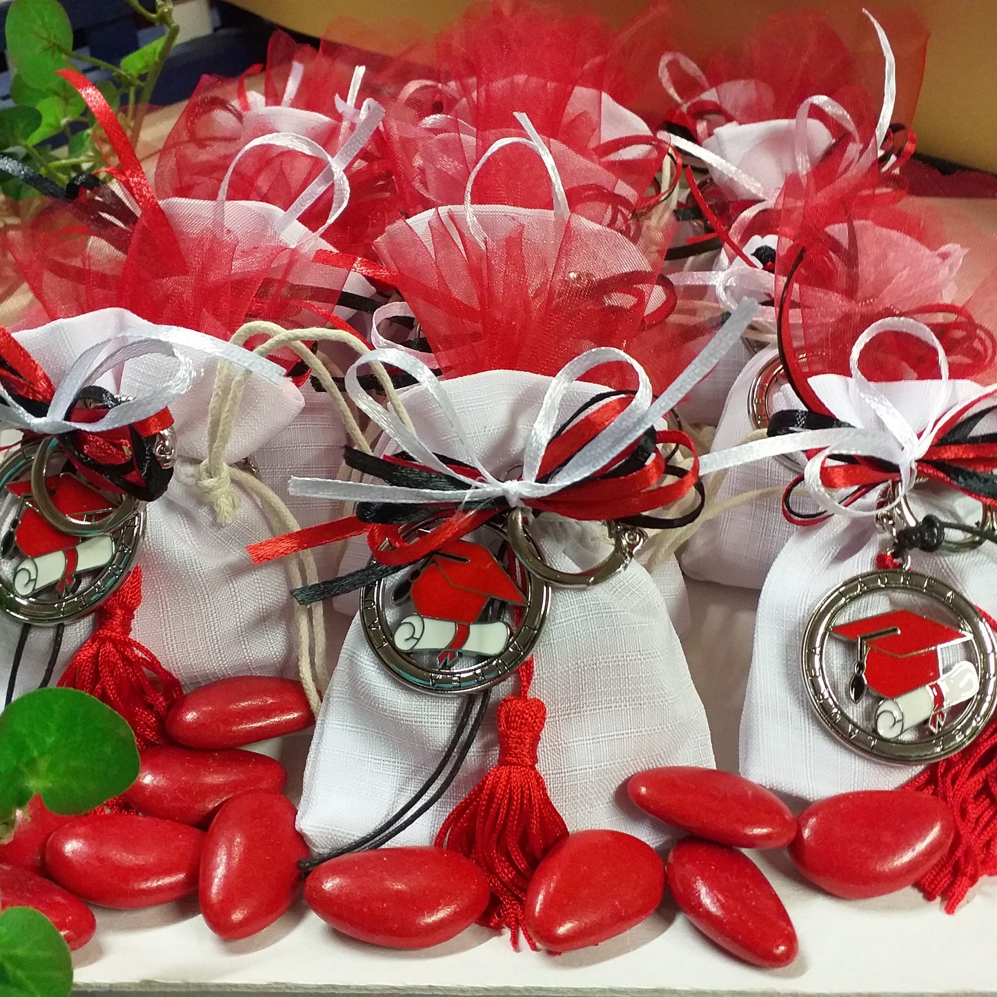 confettata di sacchetto bianco confezionato confetti tulle tris colori nastrini bianco rosso nero portachiavi tocco cappello laurea ciondolo smaltato pergamena nappina bomboniera