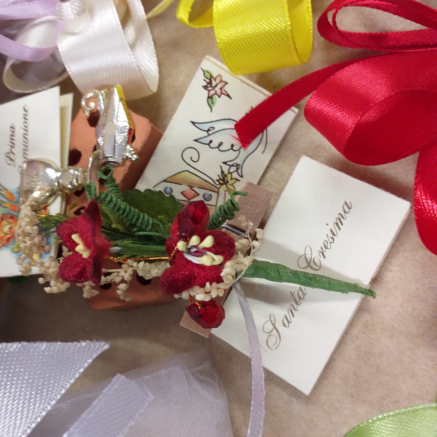 primo piano decorazioni confezionamento sacchetto Prima comunione Santa Cresima Santo Giorno bianco con simboli Calice mitria Colomba confezionato confetti bigliettino tulle fiorellini mollettina clip legno