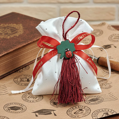 idee originali come confezionare portaconfetti laurea bomboniere sacchettino di raso bianco con ciondolo coccinella portafortuna nappina rossa,  simboli grafici vintage