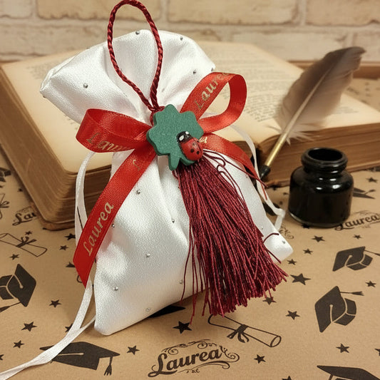 idee originali come confezionare portaconfetti laurea bomboniere sacchettino di raso bianco con ciondolo coccinella portafortuna nappina e confetti mandorla rossi,  simboli grafici vintage