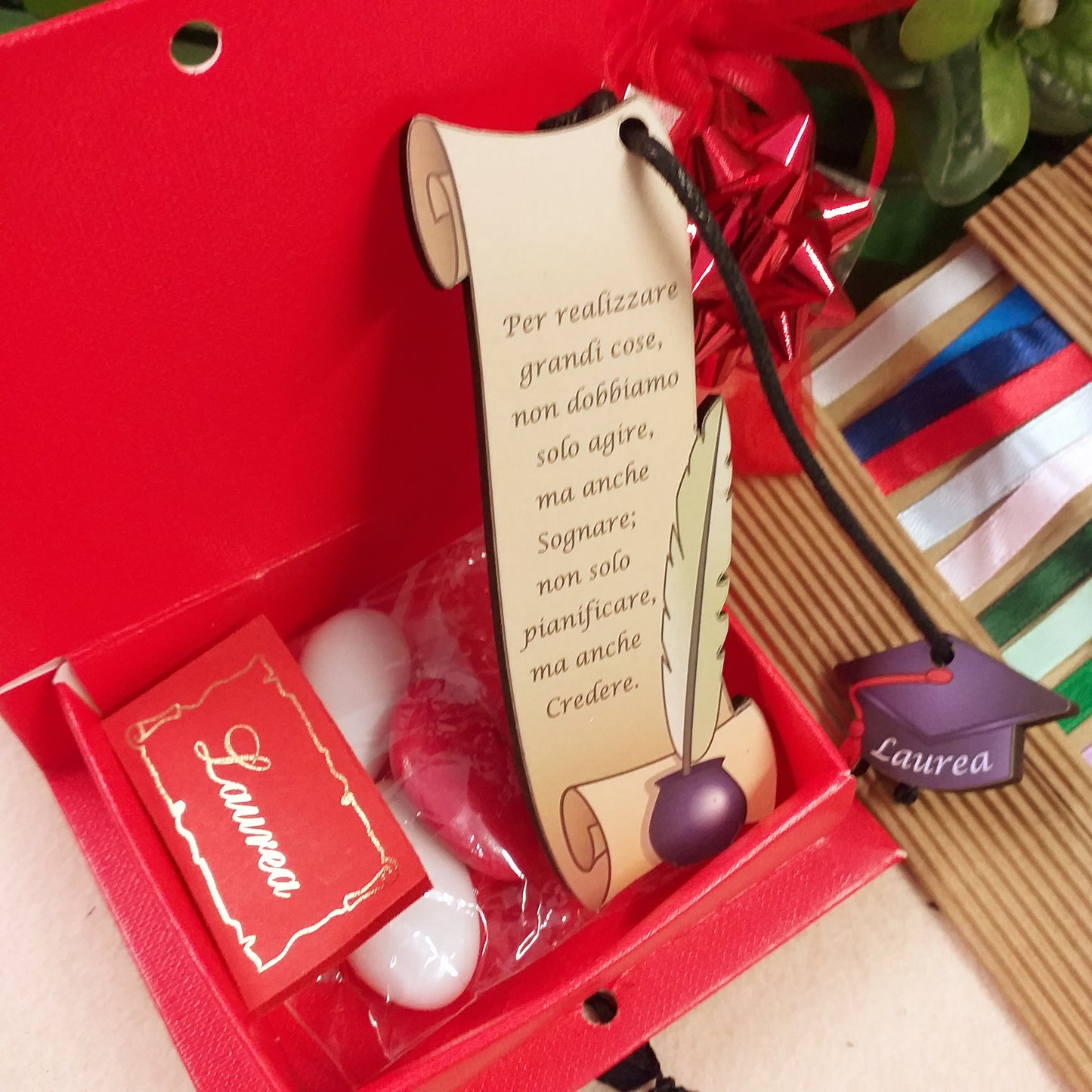 confezione con confetti bigliettino segnalibro legno pergamena inchiostro calamaio ciondolo tocco laurea cappello nero cordino bomboniera libro cartoncino rosso portaconfetti nastrino bigliettino