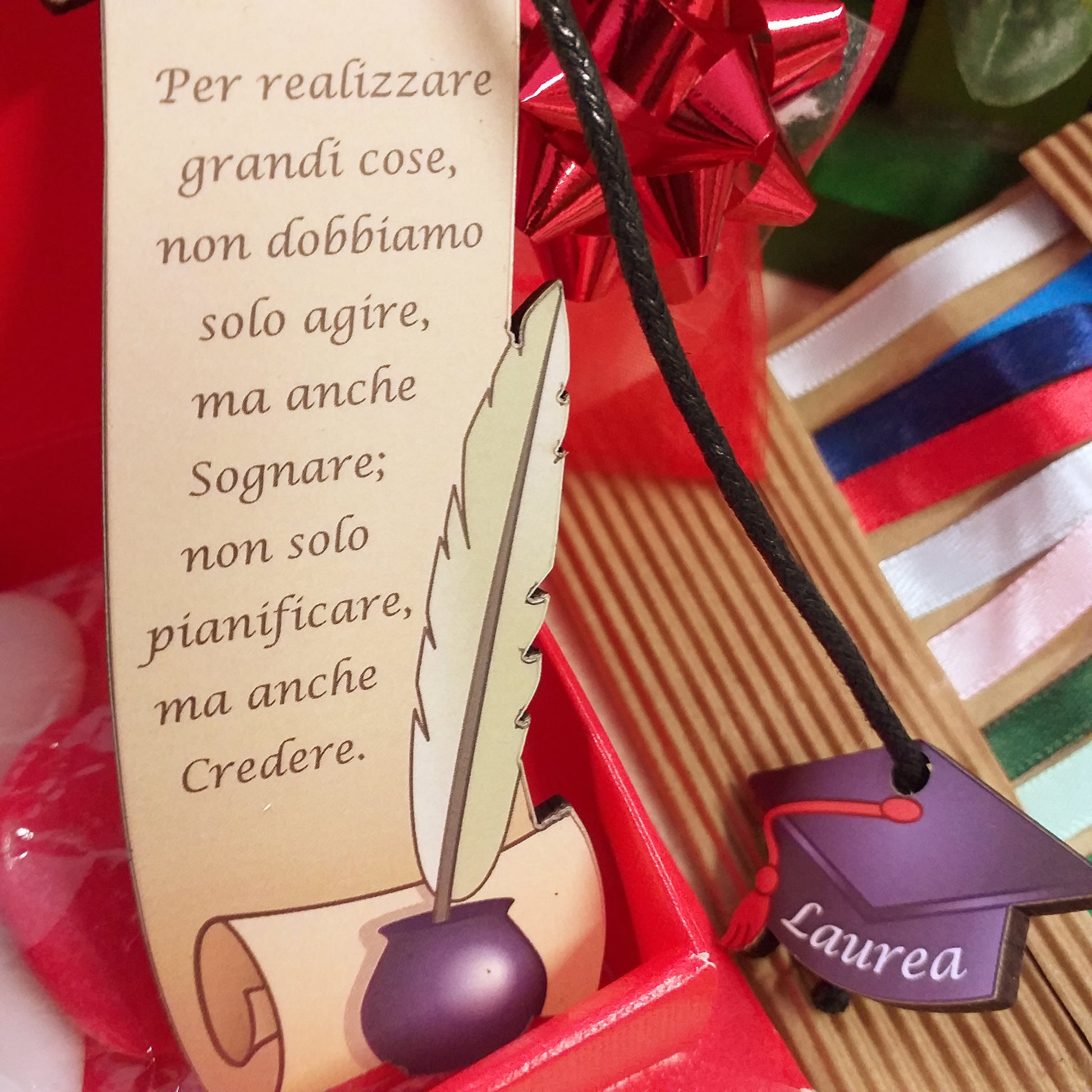 primo piano frase segnalibro legno pergamena inchiostro calamaio ciondolo tocco laurea cappello nero cordino