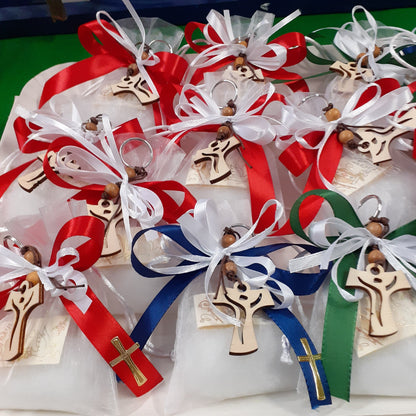 sacchettini bianchi confezionati confetti bigliettino personalizzati bomboniere comunione cresima bambini ragazzi con portachiavi tau croce legno francescana nastro bianco rosso verde blu