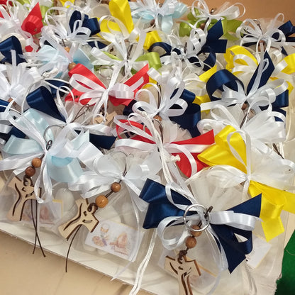 vassoio colori misti sacchetti comunione cresima nastro bambino ragazzo con portachiavi Croce francescana Tau legno naturale confezionati confetti bigliettino simboli Santo Giorno icona sacra religiosa