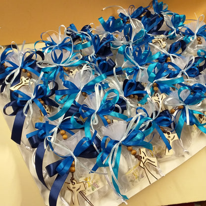 confettata di sacchetti comunione cresima nastro celeste blu sfumato bambino ragazzo con portachiavi Croce francescana Tau legno naturale confezionati confetti bigliettino simboli Santo Giorno icona sacra religiosa